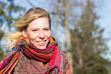 Portrait of a happy 40-year-old woman. Windy, early spring day