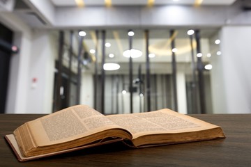Old open study book on wooden desk