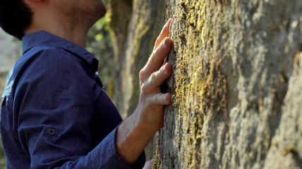 Close up of a bouldering man's hand on a rock in the forest © Thomas