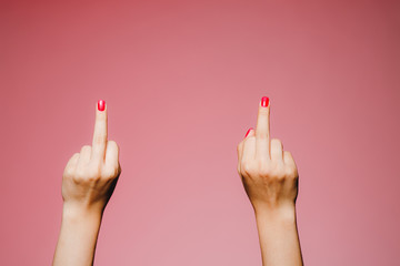 Woman's hands with bright manicure isolated on pink background go away