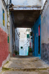 View of the old streets of Tetouan Medina quarter in Northern Morocco. A medina is typically walled, with many narrow and maze-like streets and often contain historical houses, palaces, places.