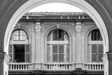 arch with three windows in the background, black and white