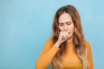The girl coughs, covers her mouth. Portrait of a girl close-up with a cold. covid-2019. Pandemic 2020.