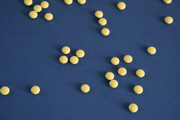 Yellow round tablets on a blue background. Free space for text