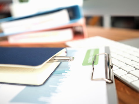 On keyboard is statistical report and notepad