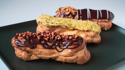 delicious and beautiful eclairs with chocolate and pistachio glazes