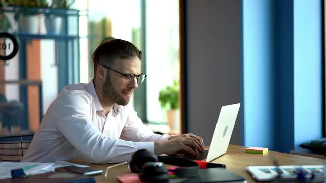 Inspired male blogger in classic spectacles for vision protection using computer technology for create interesting content publication and share to social people, talented smart casual freelancer 