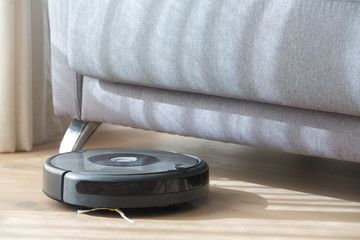 robot vacuum cleaner under a sofa.