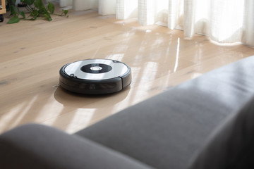 robot vacuum cleaner cleaning a wooden floor