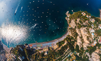 Top down aerial panorama view of Amalfi coast. Rocky shores and incredible beaches, Luxury yachts, boats and apartments overlooking Tyrrhenian Sea. Bright sunny day. Copy space. Positano, Italy © Sergey