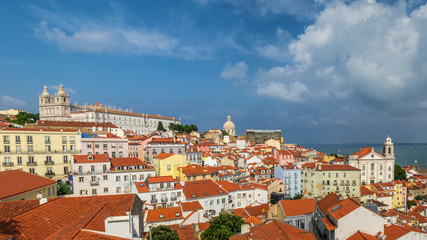 Fototapeta na wymiar A big panorama of lisbon from a terrace. All the rooftops from above and the monastery of vincent and the santo estvao chruch at the back.