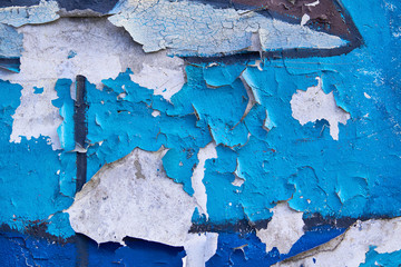 Peeling blue and brown paint on an old concrete wall. Pattern of blue and brown orange material.