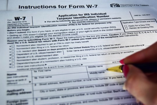 W7 tax form for US citizens, filling out a declaration and instructions. selective focus close-up.