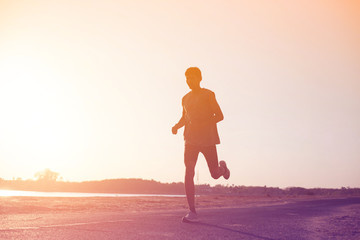 The man with runner on the street be running for exercise.