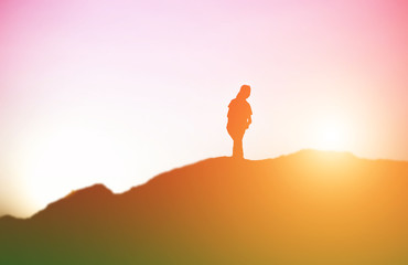 silhouette of a young woman standing alone