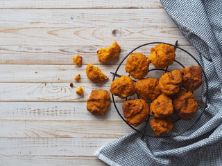 Pumpkin vegetarian or vegan cookies with raisins and cinnamon on a grid on a white wooden background with a napkin.The view from the top.