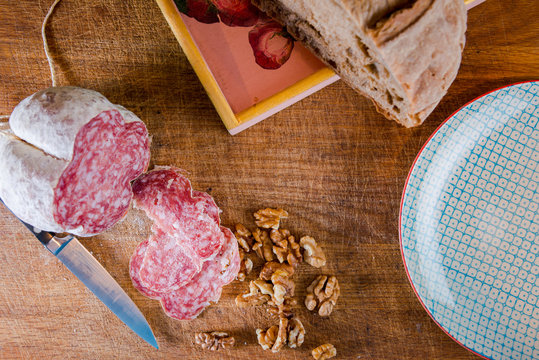 Pause mit Brotzeit in der Küche. Salami, Nüsse, Brot.