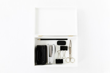 Office stationery in the wooden box. Flat lay of office accessories on white background