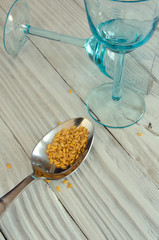Flax seeds on the background of old cutlery and glass goblets.