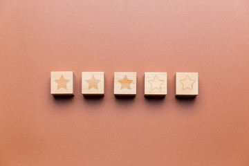 Wooden cubes with 3 stars out of 5, concept of rating and evaluation