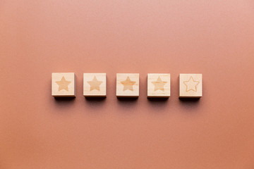 Wooden cubes with 4 stars out of 5, concept of rating and evaluation