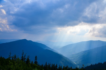 Plakat Clouds Above Sun Rays Shining on the Blue Carpathian Mountains on a cloudy fall evening in October Ukraine