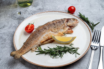 Whole trout roasted to golden crust and served with tomatoes and lemon