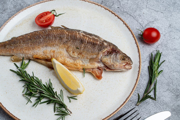 Whole trout roasted to golden crust and served with tomatoes and lemon