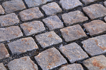 Abstract background of old cobblestone pavement close-up