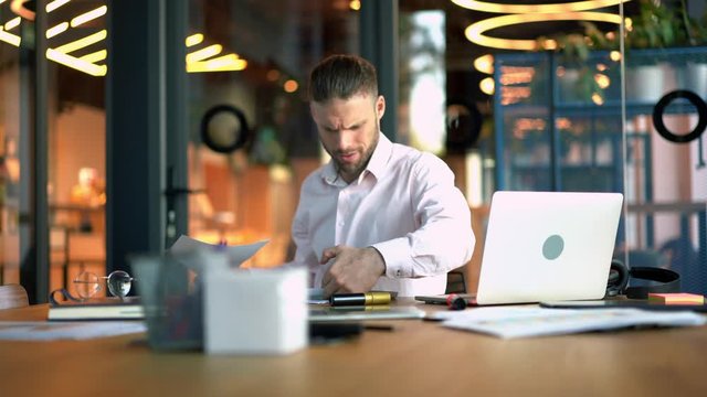 Stressful male entrepreneur received bad mobility news about capital investment disappointed with exchange results, smart casual technology user reading report during smartphone conversation