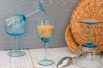 Flax seeds on the background of old cutlery and glass goblets.