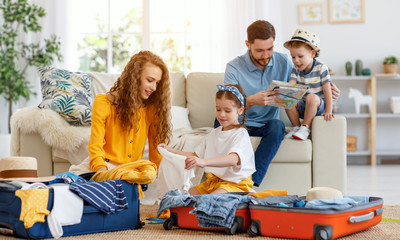 Family preparing for vacation while packing on floor at home.