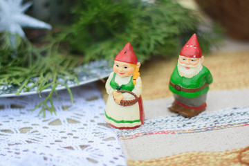 Two decorative ceramic figures of green gnomes stand on a table