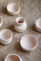 dishes made of white clay without glaze after firing on a brown background close-up. pottery
