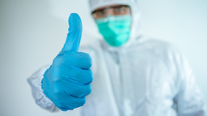Doctor hand pointing. Caucasian man in protective suit and mask giving thumb up