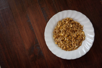Fried rice on a white plate on a brown wooden floor.