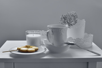 Yellow cookie on the background of light dishes.