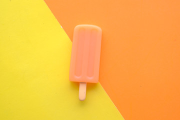 top view of orange color ice cream on color background.