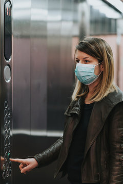 Young woman with medical mask in the elevator of an apartment building