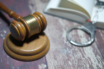 Close up of gavel, book and handcuff on table 