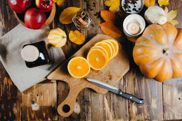 Mulled wine ingredients flat lay. Cinnamon, orange, apples, cardamom, clove, anise and red wine on wooden background. Composition of traditional winter drink.
