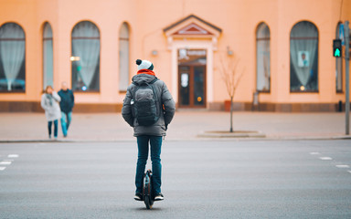 Electric unicycle. Man rides on mono wheel crosswalks on the road. Guy driving on self-balancing personal transporter with single wheel. © Tricky Shark