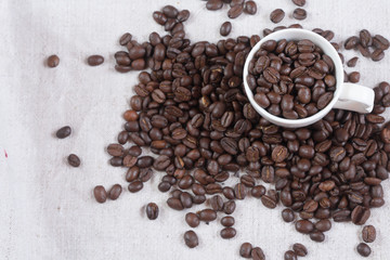  coffee beans spill out of a cup.