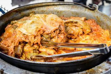 Freshly cooked large portion of cabbage rolls with meat and cabbage, a traditional Romanian food called sarmale cooked at a food market