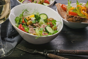 Close-up salads with vegetables and micro-greens in white bowls, canapes with pate and sweet pepper...