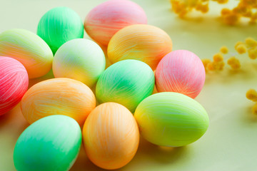 multi-colored eggs in pastel tones on a yellow background. Easter decor