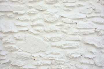 Textura de un muro hecho con piedras pintadas de blanco en la Alpujarra de Granada, España