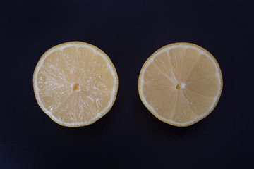 Two lemon halves against a black background