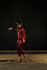 girl in a red suit posing on a black background