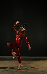 girl in a red suit posing on a black background